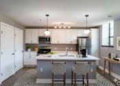 Thumbnail 4 of 29 - A kitchen with a large island and a refrigerator.