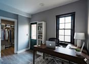 Thumbnail 10 of 29 - A room with a desk, chair, and a laptop.