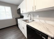 Thumbnail 15 of 61 - a kitchen with white cabinets and a black stove top oven at Highview Manor Apartments, Fairport, NY, 14450
