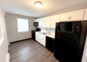 Thumbnail 16 of 61 - a kitchen with white cabinets and black appliances at Highview Manor Apartments, Fairport, NY, 14450