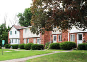 Thumbnail 39 of 61 - a picture of a brick apartment building with a sidewalk in front of it