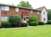 Thumbnail 42 of 61 - a red brick house with white siding and a green lawn