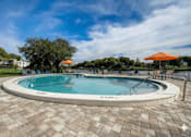 Thumbnail 34 of 47 - A round swimming pool surrounded by a brick patio.