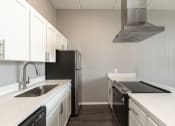Thumbnail 8 of 47 - a kitchen with white cabinets and black appliances