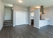 Thumbnail 10 of 47 - an empty living room with a kitchen in the background