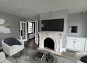 Thumbnail 2 of 29 - A living room with a fireplace and a television.