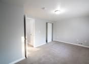 Thumbnail 36 of 103 - a living room with a carpeted floor and a door to a bedroom at Willowbrooke Apartments, New York, 14420