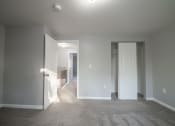 Thumbnail 14 of 103 - a living room with a carpeted floor and a door to a bedroom at Willowbrooke Apartments, Brockport, NY
