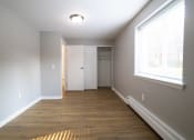 Thumbnail 76 of 103 - Empty room with wood floors and a large window at Willowbrooke Apartments, Brockport, New York