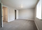 Thumbnail 52 of 103 - an empty living room with carpet and a door to a closet at Willowbrooke Apartments, New York, 14420