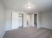 Thumbnail 47 of 103 - an empty living room with white doors and a carpeted floor at Willowbrooke Apartments, Brockport, 14420