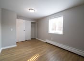 Thumbnail 77 of 103 - an empty living room with wooden floors and a window view at Willowbrooke Apartments, New York, 14420