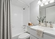 Thumbnail 22 of 58 - Bathroom with white vanity and tub shower combo at The Residences at Soho Apartments, Tampa