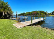 Thumbnail 23 of 47 - a dock on a body of water with trees in the background