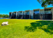 Thumbnail 38 of 47 - a row of apartments overlooking a grassy area and a body of water