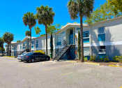 Thumbnail 32 of 47 - a row of apartment buildings with palm trees in front of them