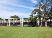 Thumbnail 35 of 47 - a row of apartments with a grassy area in the foreground and trees in the background