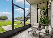 Thumbnail 24 of 58 - Screened patio with seating and waterfront view at The Residences at Soho Apartments, Tampa, 33607