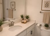 Thumbnail 15 of 53 - A white toilet sits next to a sink in a bathroom.