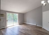 Thumbnail 5 of 15 - an empty living room with gray walls and a sliding glass door