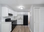Thumbnail 1 of 15 - an empty kitchen with white cabinets and black appliances