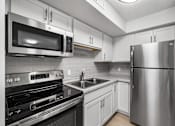 Thumbnail 13 of 26 - a kitchen with stainless steel appliances and white cabinets