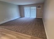 Thumbnail 31 of 48 - a living room with a window and a carpeted floor