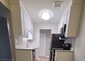 Thumbnail 42 of 48 - a kitchen and living room with wood floors and white cabinets