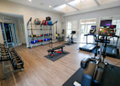 Thumbnail 42 of 49 - A gym with a variety of equipment including treadmills, weights, and exercise machines.