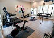 Thumbnail 40 of 49 - A gym with a variety of equipment including treadmills, weights, and exercise bikes.