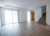 Thumbnail 12 of 36 - an empty living room with wood floors and a staircase