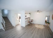 Thumbnail 7 of 36 - an empty living room with a staircase and a kitchen