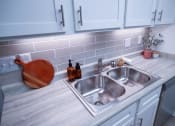 Thumbnail 6 of 36 - a stainless steel sink in a kitchen with white cabinets
