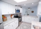 Thumbnail 3 of 36 - a white kitchen with a stove and a microwave