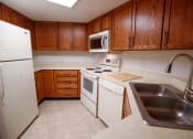Thumbnail 16 of 49 - a kitchen with a white stove top oven next to a sink