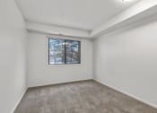 Thumbnail 20 of 49 - a bedroom with a large window and a carpeted floor