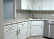 Thumbnail 18 of 49 - A kitchen with white cabinets and a stainless steel dishwasher.