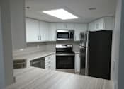 Thumbnail 17 of 49 - A kitchen with a black refrigerator, stove, and oven.