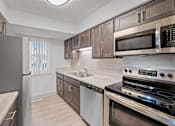 Thumbnail 5 of 25 - a kitchen with stainless steel appliances and wooden cabinets