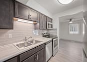 Thumbnail 4 of 25 - an empty kitchen with stainless steel appliances and wooden cabinets