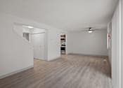 Thumbnail 13 of 25 - an empty living room with white walls and a ceiling fan