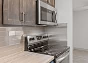 Thumbnail 12 of 25 - an empty kitchen with a stove and a microwave