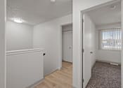 Thumbnail 16 of 25 - the living room and dining room of an apartment with white walls and wood flooring