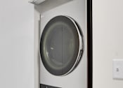 Thumbnail 12 of 36 - A white and black front loading washing machine in a cabinet.