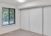 Thumbnail 16 of 36 - A room with a window and sliding doors.