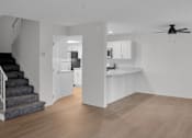 Thumbnail 2 of 36 - A spacious kitchen and living room with a staircase on the left side.