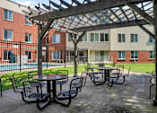 Thumbnail 7 of 30 - A patio with a table and chairs under a pergola.
