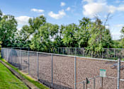 Thumbnail 43 of 67 - A chain link fence surrounds a tennis court.