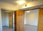 Thumbnail 45 of 49 - A room with carpeted floor and three doors.
