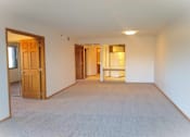Thumbnail 40 of 49 - A room with a carpeted floor and a door on the left side.